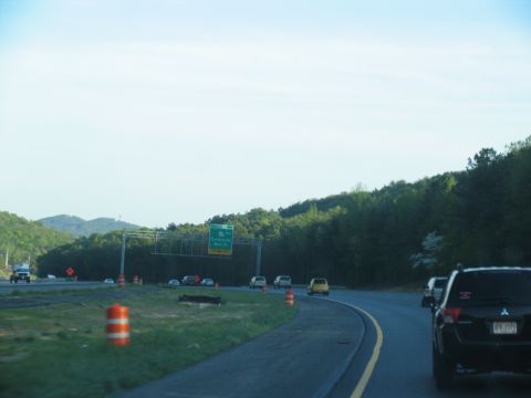 1995 Ford C-350 (Centurion Conversions) - Driving on a highway with multiple vehicles and construction barrels visible.