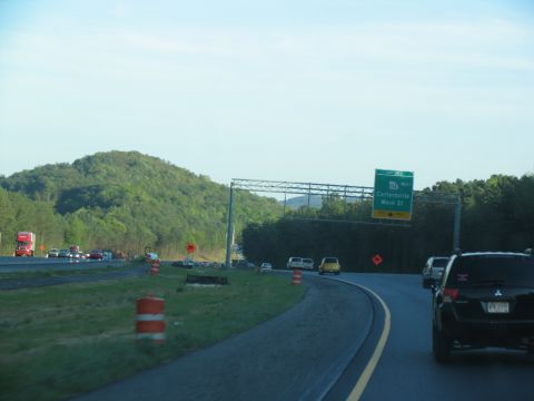1995 Ford C-350 (Centurion Conversions) - Driving on the highway with traffic and construction barrels visible.