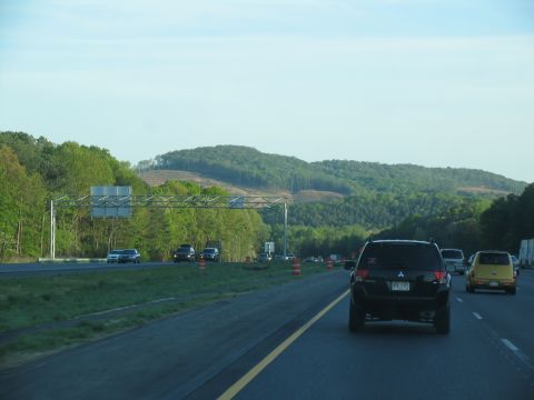 1995 Ford C-350 (Centurion Conversions) - Driving on a highway with trees and hills in the background.