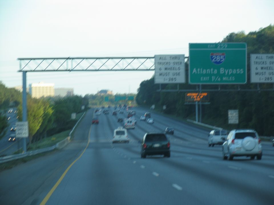 Highway traffic with multiple vehicles and overhead signs for Atlanta Bypass