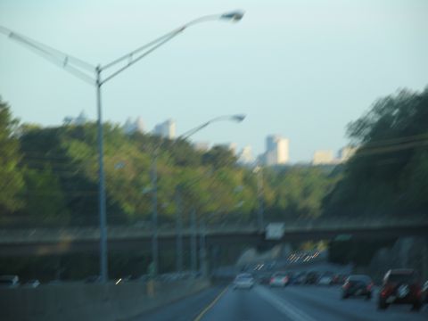 1995 Ford C-350 (Centurion Conversions) - Driving on a highway with a view of trees and distant buildings.