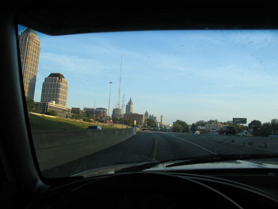 View from car dashboard of city skyline under a clear blue sky