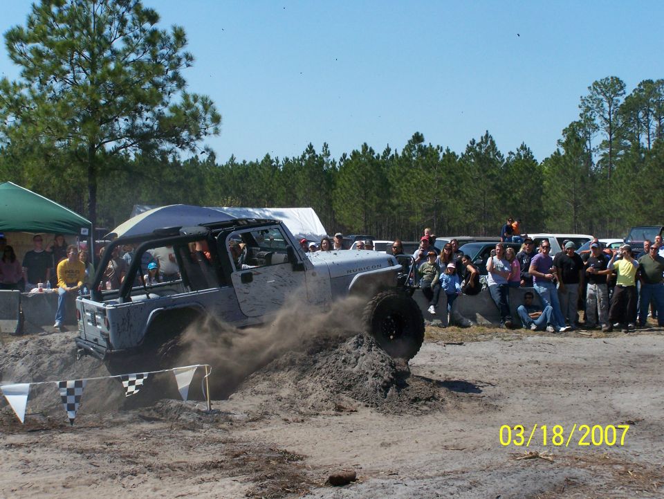 Silver Jeep Wrangler Rubicon kicking up dirt off-road
