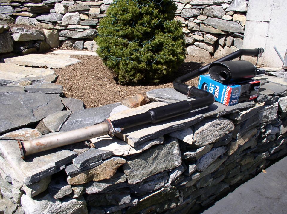 Exhaust system part on stone wall with Makita box