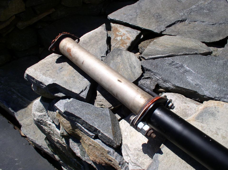 Exhaust pipe section resting on rocks