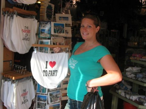 1991 Ford Bronco - Woman holding novelty underwear in a shop selling humorous apparel and tourist-themed items.