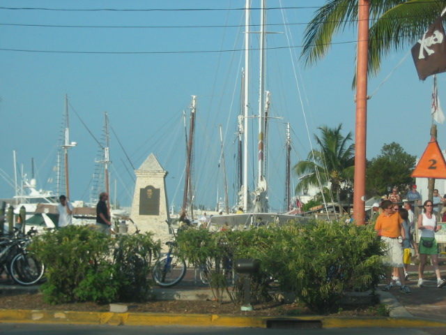 Boats docked in a harbor with people walking nearby