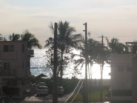 1991 Ford Bronco - A view of the ocean and beach with palm trees and buildings in the foreground.
