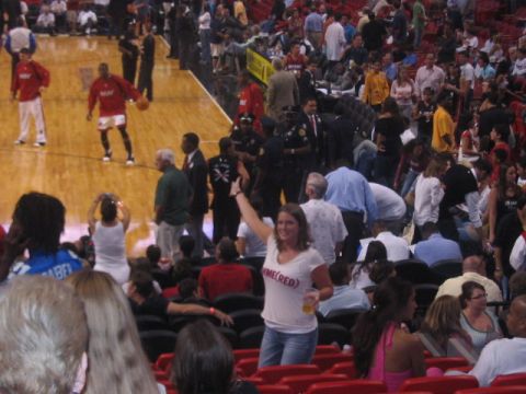 1991 Ford Bronco - A woman in a white t-shirt with red lettering raises her hand while attending a basketball game.