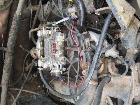 1986 Ford Bronco - Close-up view of an engine bay, focusing on the carburetor and associated wiring.