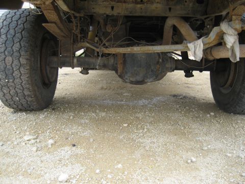 1986 Ford Bronco - The underside of a truck shows its rear axle, suspension, and exhaust system.