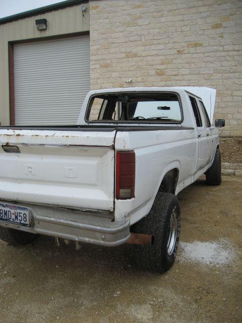1986 Ford Bronco - White Ford pickup truck, likely from the early 1980s, parked outside a building.