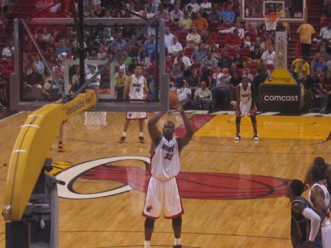 1991 Ford Bronco - A basketball player in a white uniform with the number 32 on it shoots a free throw during a game.