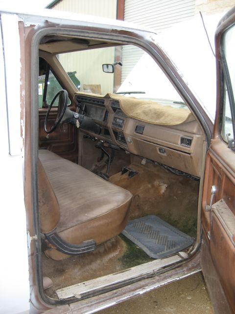 1986 Ford Bronco - Interior of an older Ford truck, showing the bench seat and dashboard.