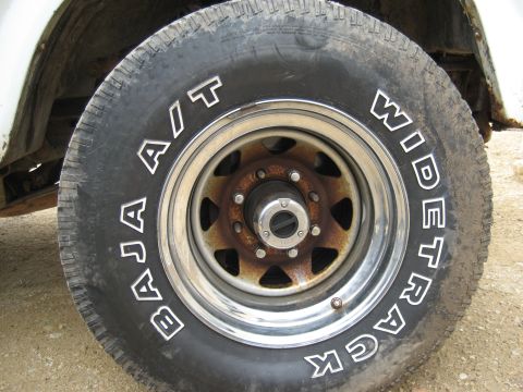 1986 Ford Bronco - This close-up shows a Baja A/T Widetrack tire mounted on a rusty wheel, likely from a truck or SUV.