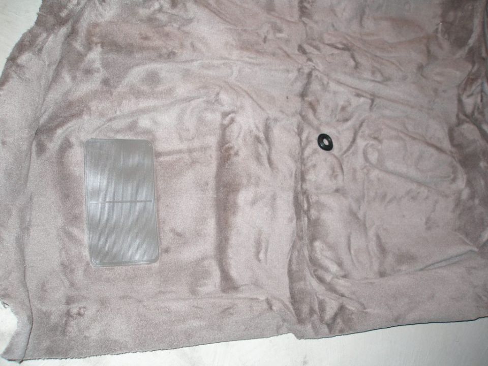Car carpet with a clear plastic mat and a black grommet