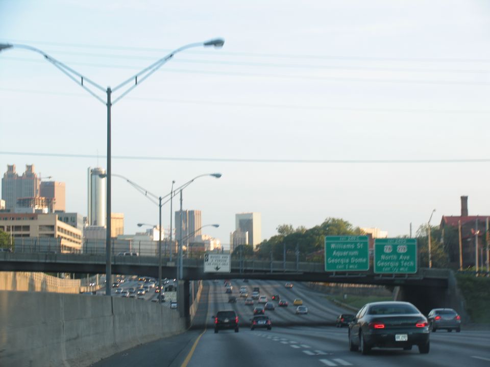 Cars on a highway with city buildings in the background