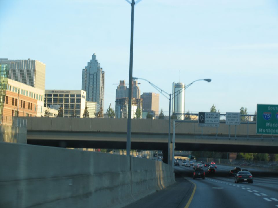 Highway driving past concrete barriers with Atlanta skyline in background
