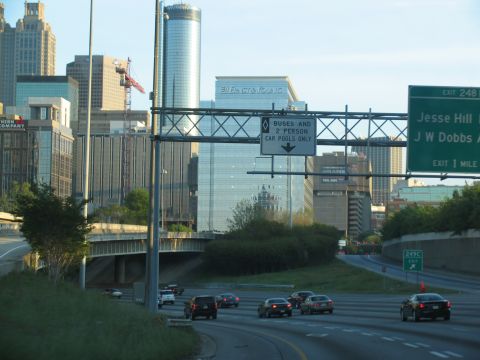 1995 Ford C-350 (Centurion Conversions) - Vehicles travel on a highway with a city skyline in the background, tall buildings and a construction crane.