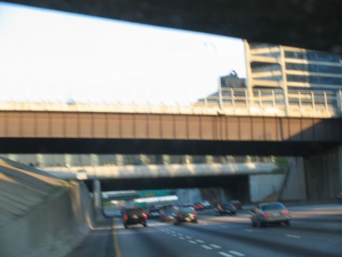 1995 Ford C-350 (Centurion Conversions) - Driving on a multi-lane highway with traffic and elevated structures.