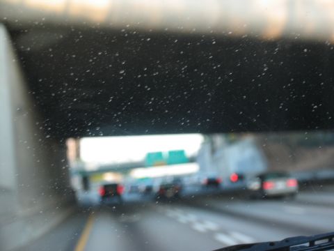 1995 Ford C-350 (Centurion Conversions) - Traffic moves along a highway, passing under a dark overpass with visible water droplets on the windshield.
