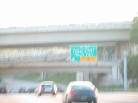 1995 Ford C-350 (Centurion Conversions) - Driving on the highway past other cars and an overpass with a street sign.