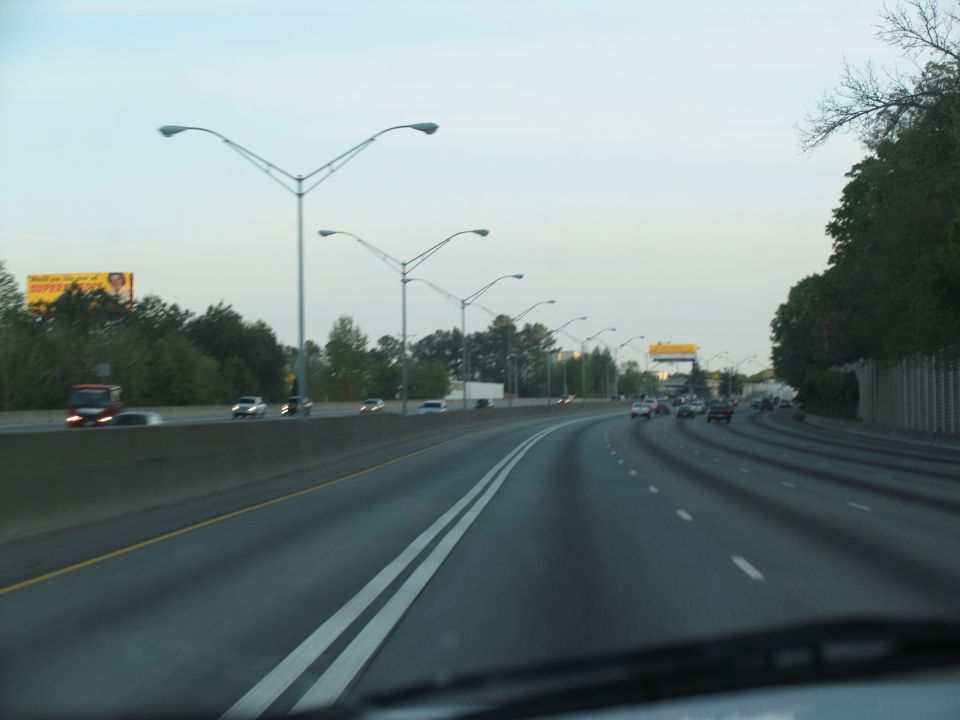 Highway scene with traffic, streetlights, and a billboard