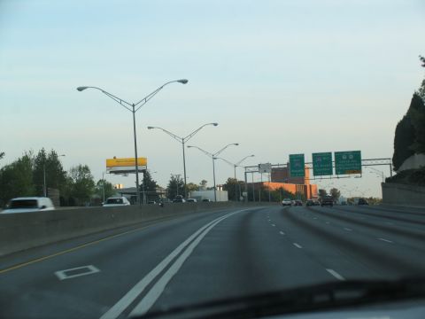 1995 Ford C-350 (Centurion Conversions) - Driving on a multi-lane highway with overhead streetlights and directional signs visible.