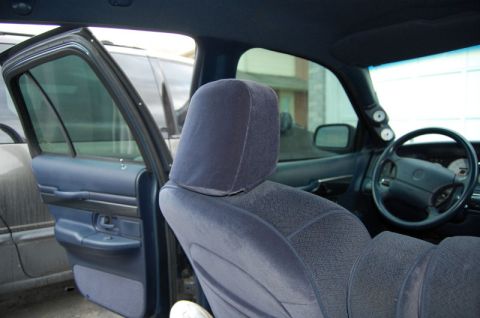 1985 Mercury Grand Marquis - Interior view of a car, showing a headrest, door panel, steering wheel, and aftermarket gauges.