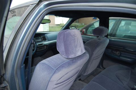 1985 Mercury Grand Marquis - The interior of a blue sedan is visible, with a second vehicle seen through the rear window.
