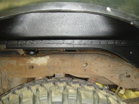 1996 Ford Bronco - Close-up view of a vehicle's inner fender well and tire, showing rust on the frame.