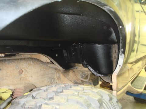 1996 Ford Bronco - Close-up view of the inner fender well, showing protective coating and chassis elements.