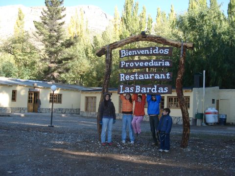 1986 Ford Bronco - A group of people stand under a rustic wooden sign for "Las Bardas" restaurant, with buildings and trees in the background.