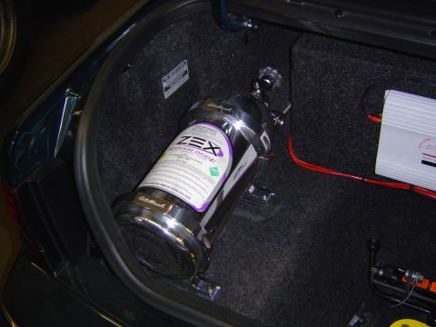 1995 Ford Thunderbird - A ZEX nitrous oxide bottle is mounted in the trunk of a car, alongside an amplifier and wiring.