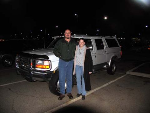 1995 Ford C-350 (Centurion Conversions) - Two people pose with a 1995 Ford C-350 (Centurion Conversions) in a parking lot at night.
