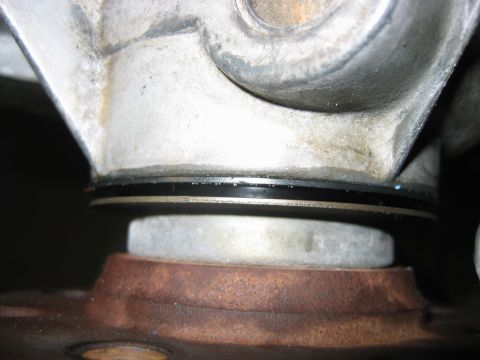 1992 Ford Bronco - Close-up of a cast metal component with two black seals or O-rings visible at a joint, sitting above a rusted circular flange. Likely a dri…