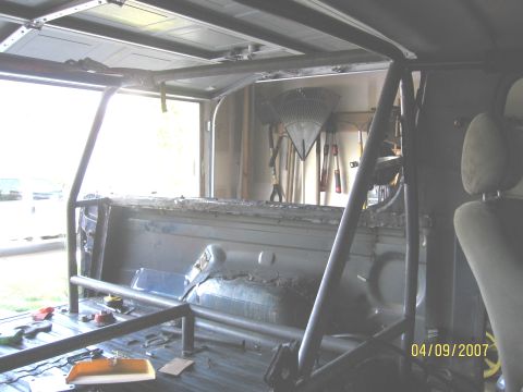 1994 Ford Bronco - The interior of a vehicle shows a custom roll cage, with tools visible in the background and a date stamp of 04/09/2007.