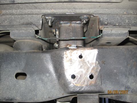 1994 Ford Bronco - Close-up of a custom suspension mount welded onto a vehicle's frame.