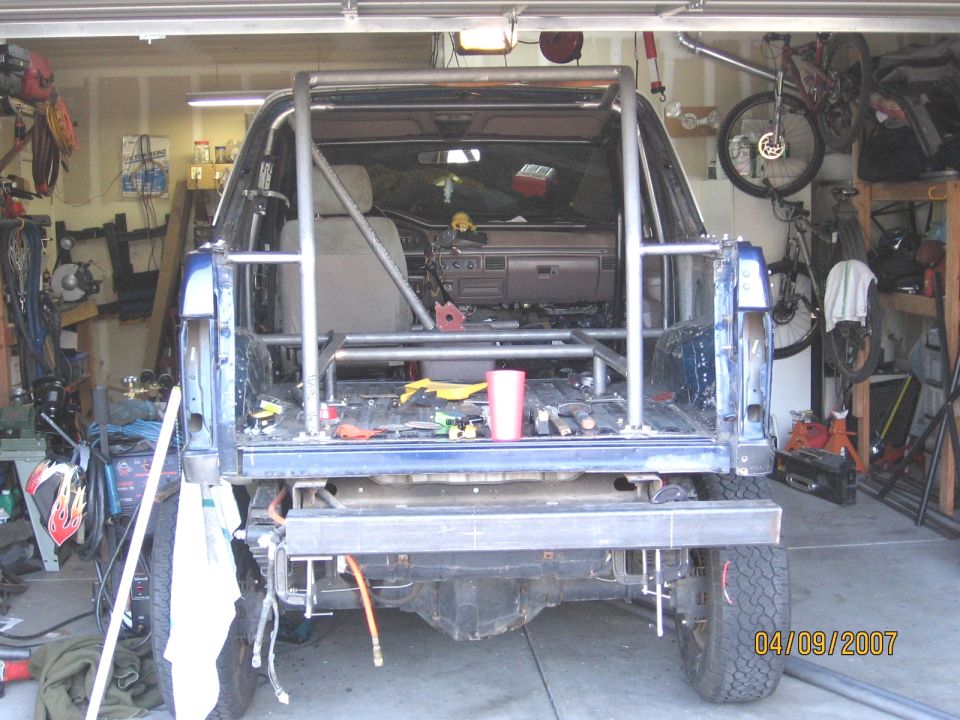 blue SUV in garage with custom roll cage installed in the bed and interior