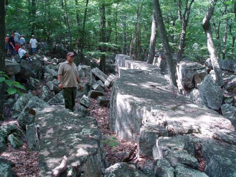 1969 Ford Bronco - A group of people explore a rocky, wooded landscape, with a Supermotors logo in the lower right corner.