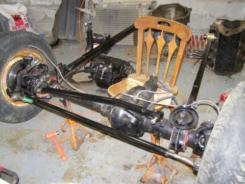 1993 Ford Bronco - This image shows a disassembled vehicle chassis with its drivetrain and suspension components laid out.