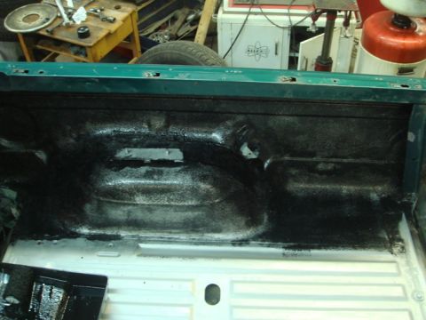 1996 Ford Bronco - Applying black spray-on liner to the interior of a truck bed.