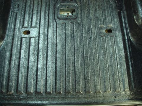 1996 Ford Bronco - Close-up view of a textured truck bed liner, showing its ribbed surface and mounting points.