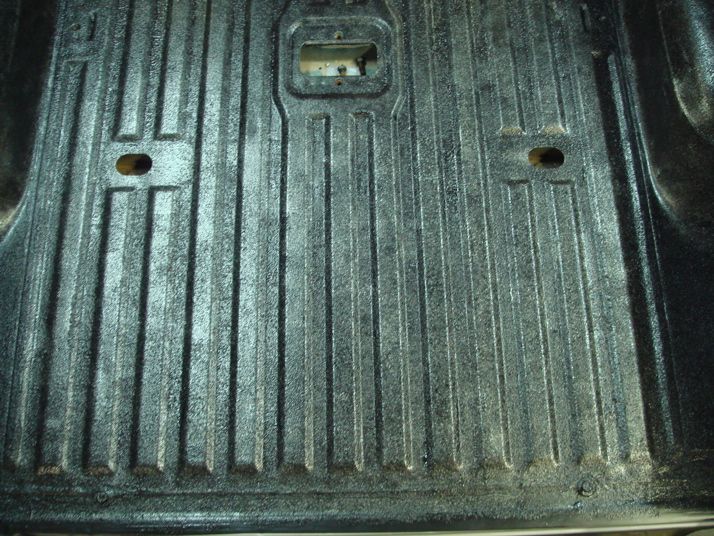 Textured truck bed liner with vertical ridges and two mounting holes