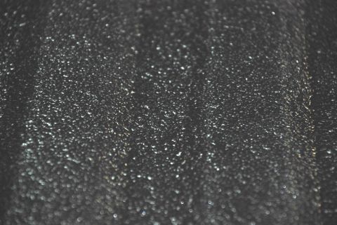 1996 Ford Bronco - The image shows a close-up of a textured black surface with many small, reflective particles.