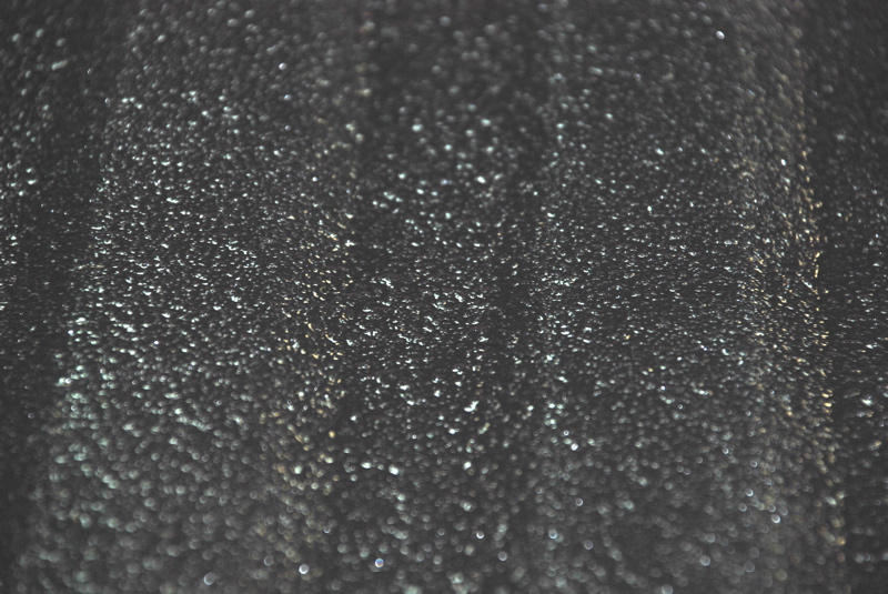 Close-up of a dark, textured surface with small reflective particles