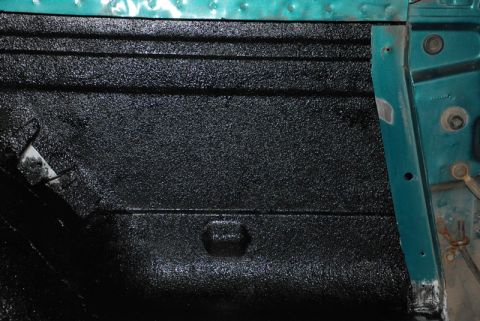 1996 Ford Bronco - Close-up of a vehicle's interior door panel coated with black spray-on bedliner material.