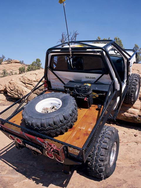 1974 Ford F-100 - Modified 1974 Ford F-100 pickup truck with a flatbed and spare tire, seen off-road.