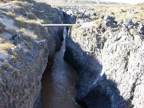 1986 Ford Bronco - A narrow canyon carved by a river, with a wooden bridge overhead.