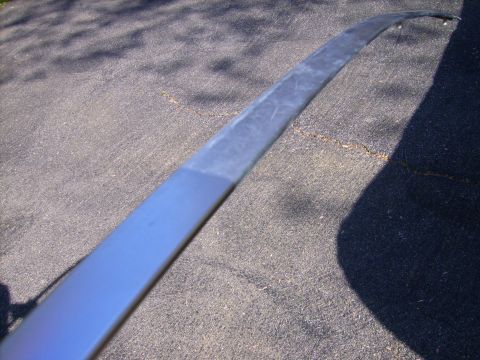 1982 Ford Crown Victoria LTD - A single car trim piece is shown on an asphalt surface, casting a shadow.